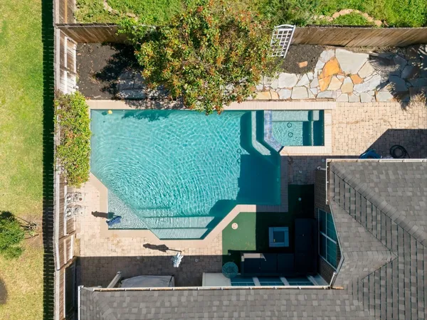 an aerial view of residential houses with outdoor space and trees