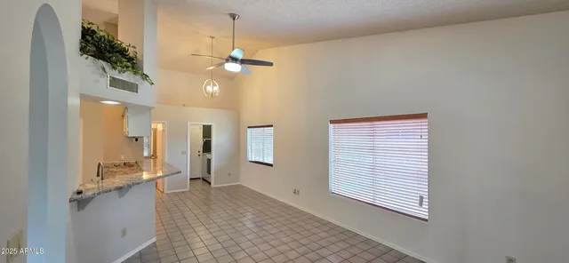 a view of a hallway with chandelier fan and wooden floor