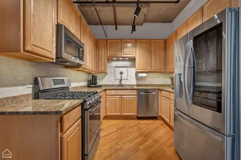 a kitchen with stainless steel appliances granite countertop a sink stove and refrigerator