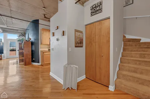 a view of a hallway with wooden floor and staircase