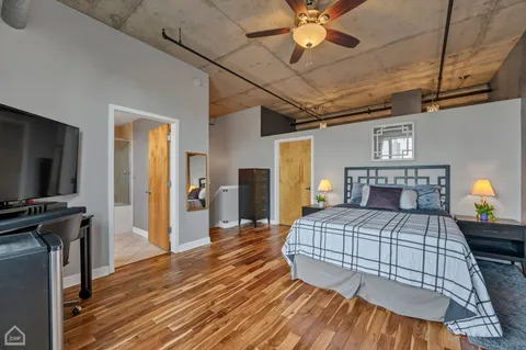 a bedroom with a bed and a flat tv screen on dresser