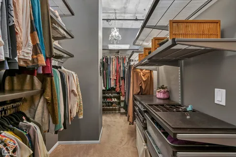 a view of walk in closet with clothes and shoes