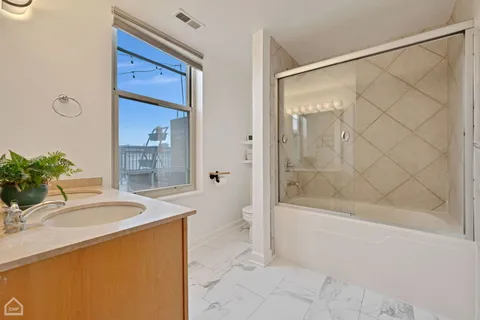 a bathroom with a granite countertop sink a toilet and shower