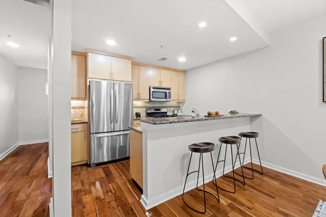a kitchen with granite countertop a refrigerator stove and microwave