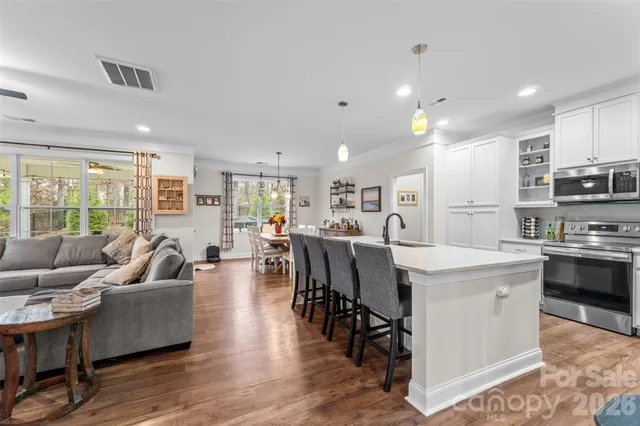 a kitchen with kitchen island white cabinets and stainless steel appliances