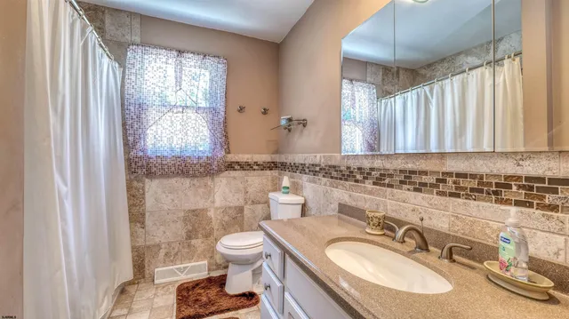 a bathroom with a granite countertop sink toilet and shower