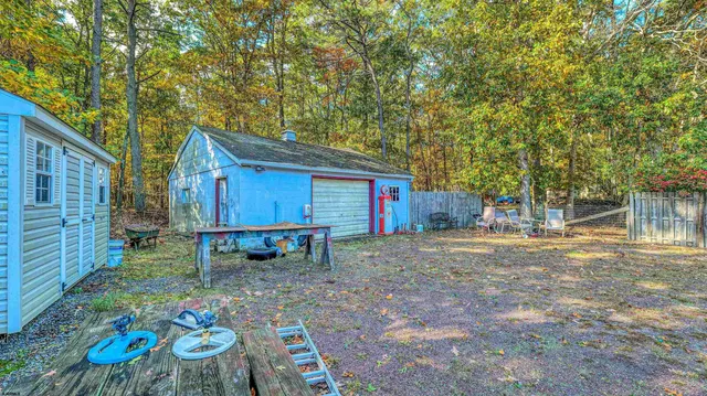 a view of backyard with table and chairs and wooden fence