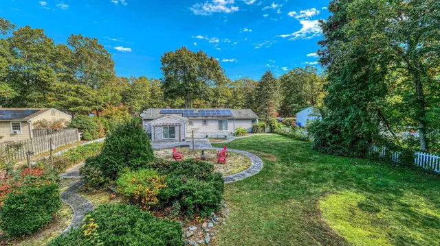 a view of a house with a yard and tree s