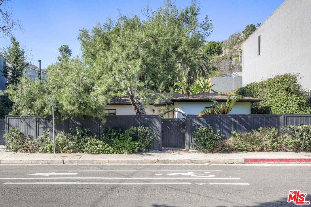 a view of a house with a yard and a street