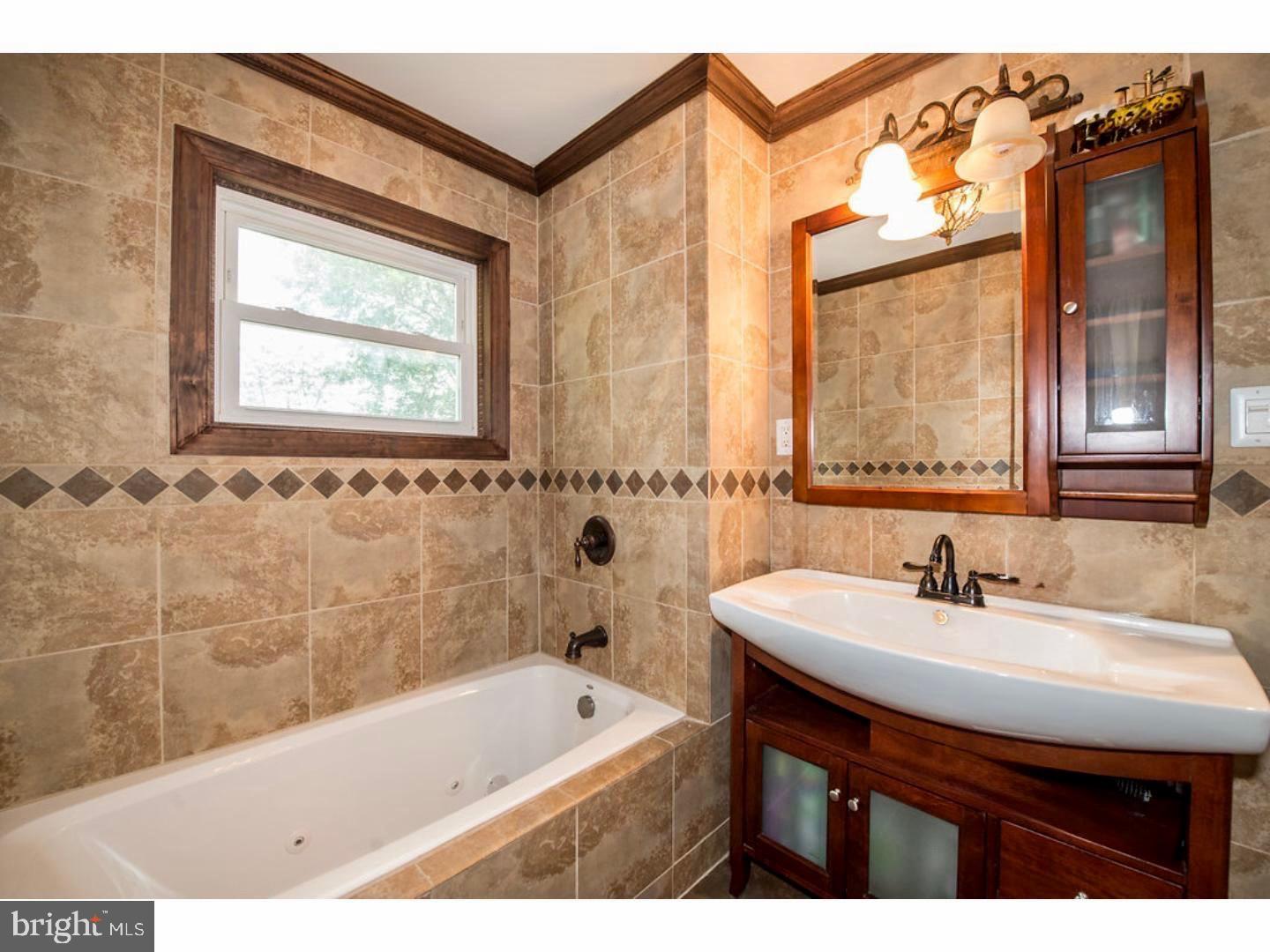 1755 Rockwell Road Abington, PA 19001 - Photo 10 of 19 a bathroom with a sink a bathtub and a window