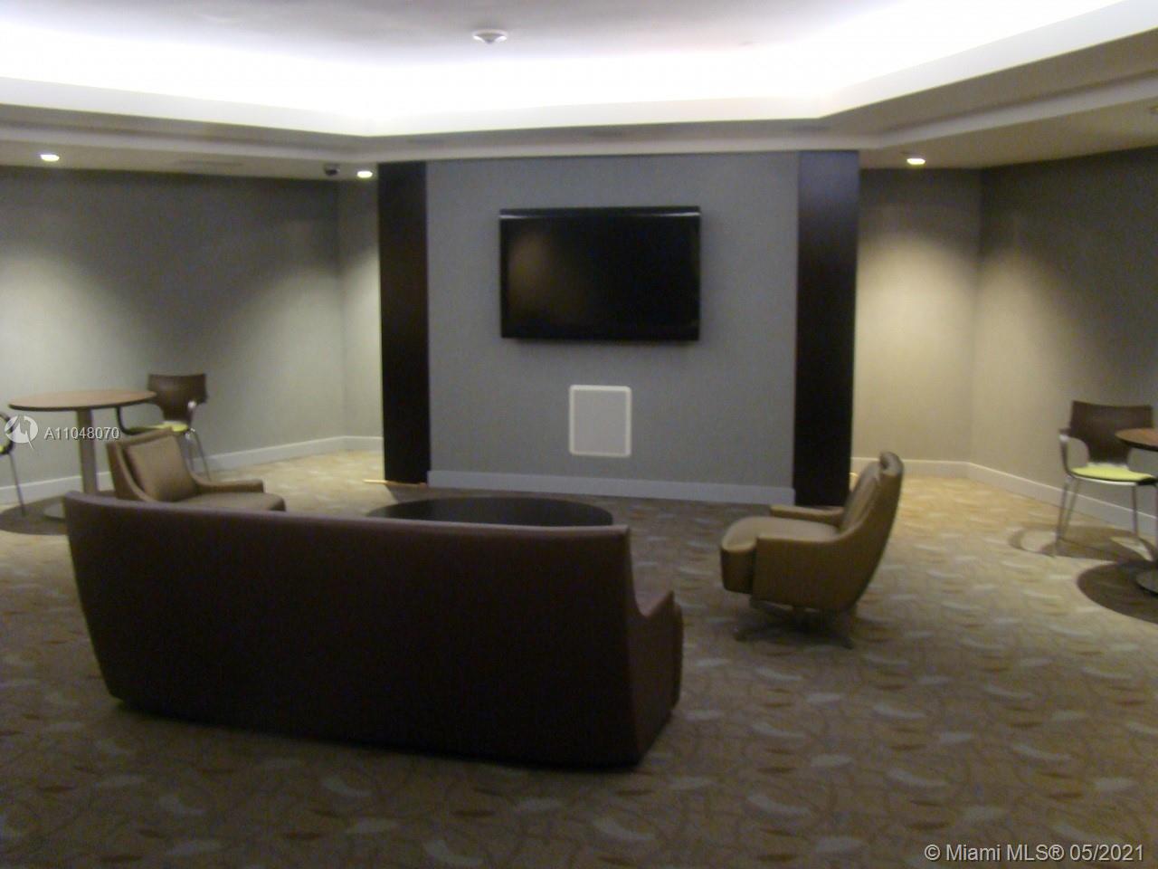 1121 Crandon Boulevard, Unit D404 Key Biscayne, FL 33149 - Photo 16 of 27 a living room with furniture and a flat screen tv