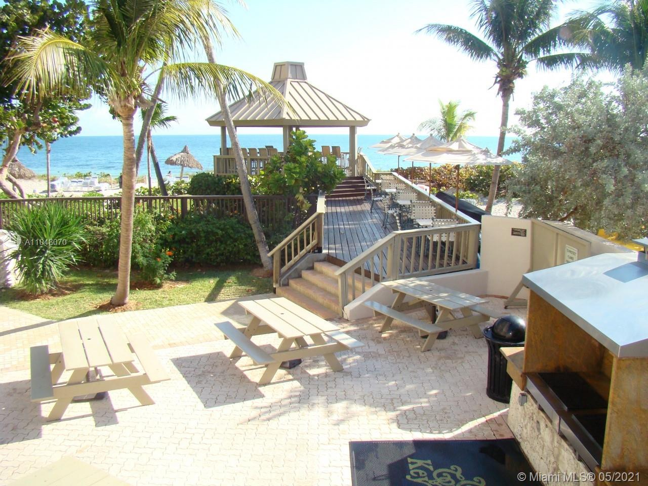 1121 Crandon Boulevard, Unit D404 Key Biscayne, FL 33149 - Photo 23 of 27 a view of a patio with table and chairs potted plants with wooden floor
