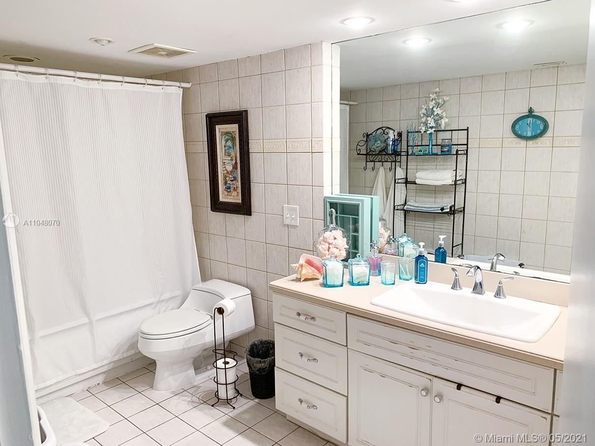 1121 Crandon Boulevard, Unit D404 Key Biscayne, FL 33149 - Photo 5 of 27 a bathroom with a double vanity sink toilet and a mirror