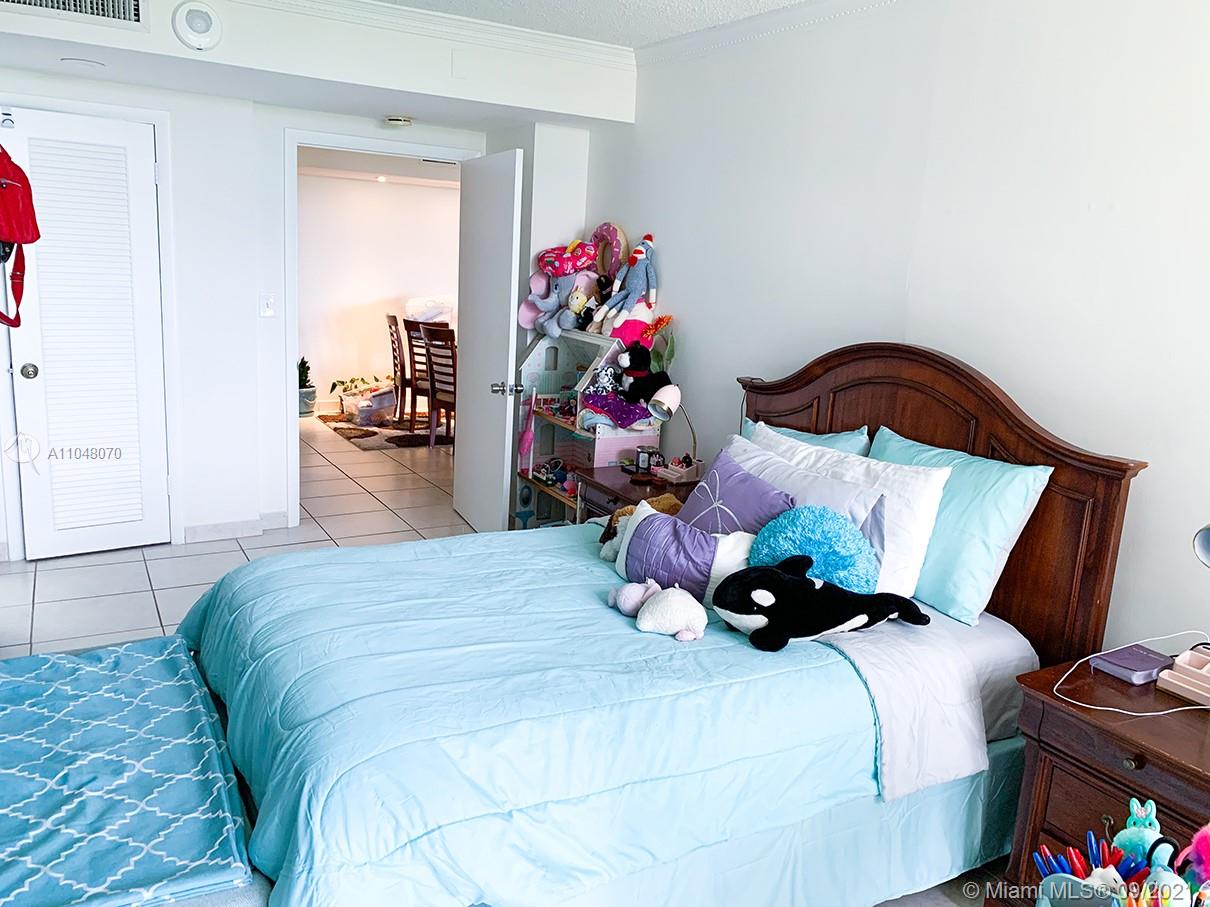 1121 Crandon Boulevard, Unit D404 Key Biscayne, FL 33149 - Photo 6 of 27 a bedroom with bed and wooden floor