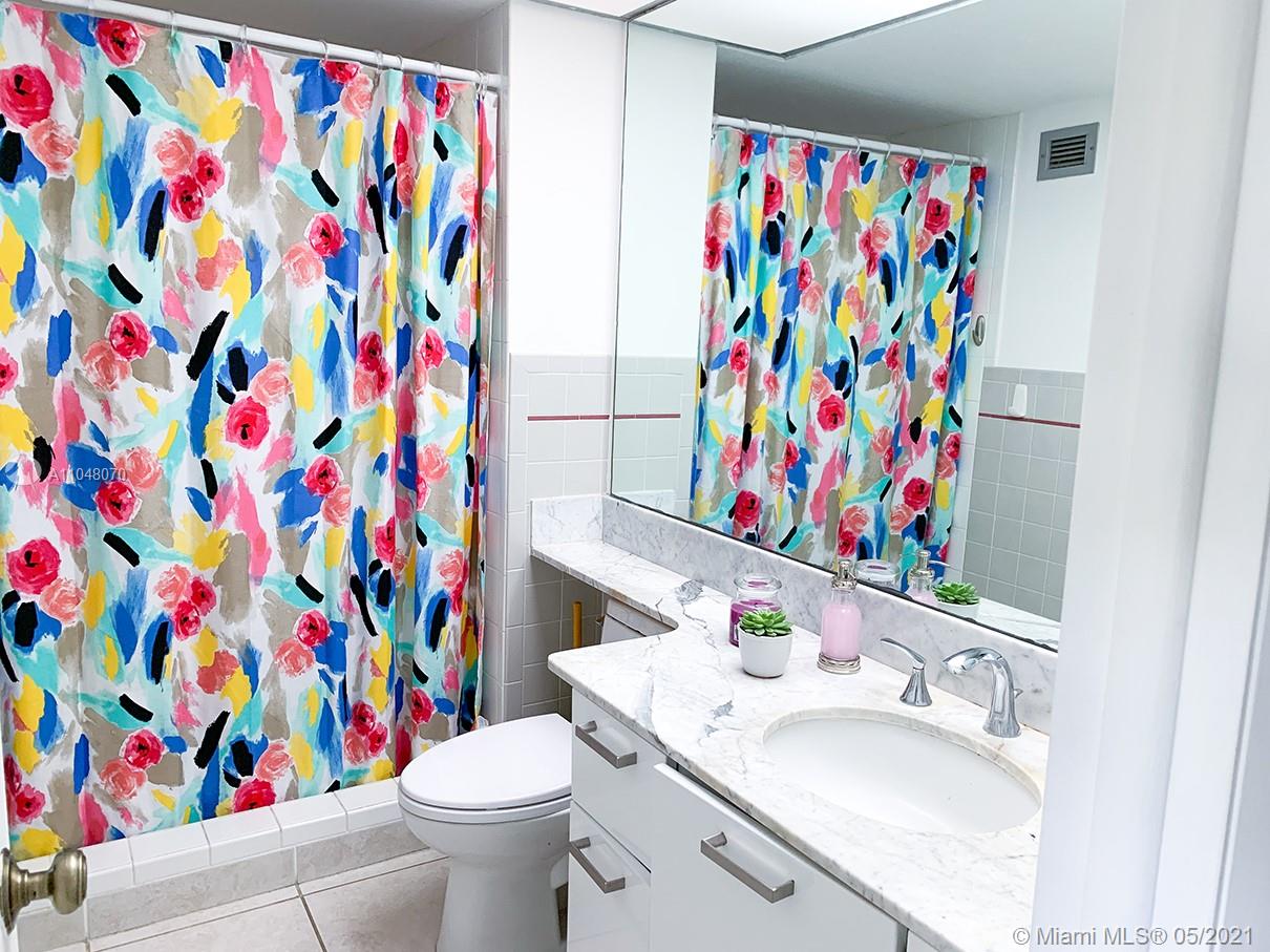 1121 Crandon Boulevard, Unit D404 Key Biscayne, FL 33149 - Photo 7 of 27 a bathroom with a sink mirror and toilet