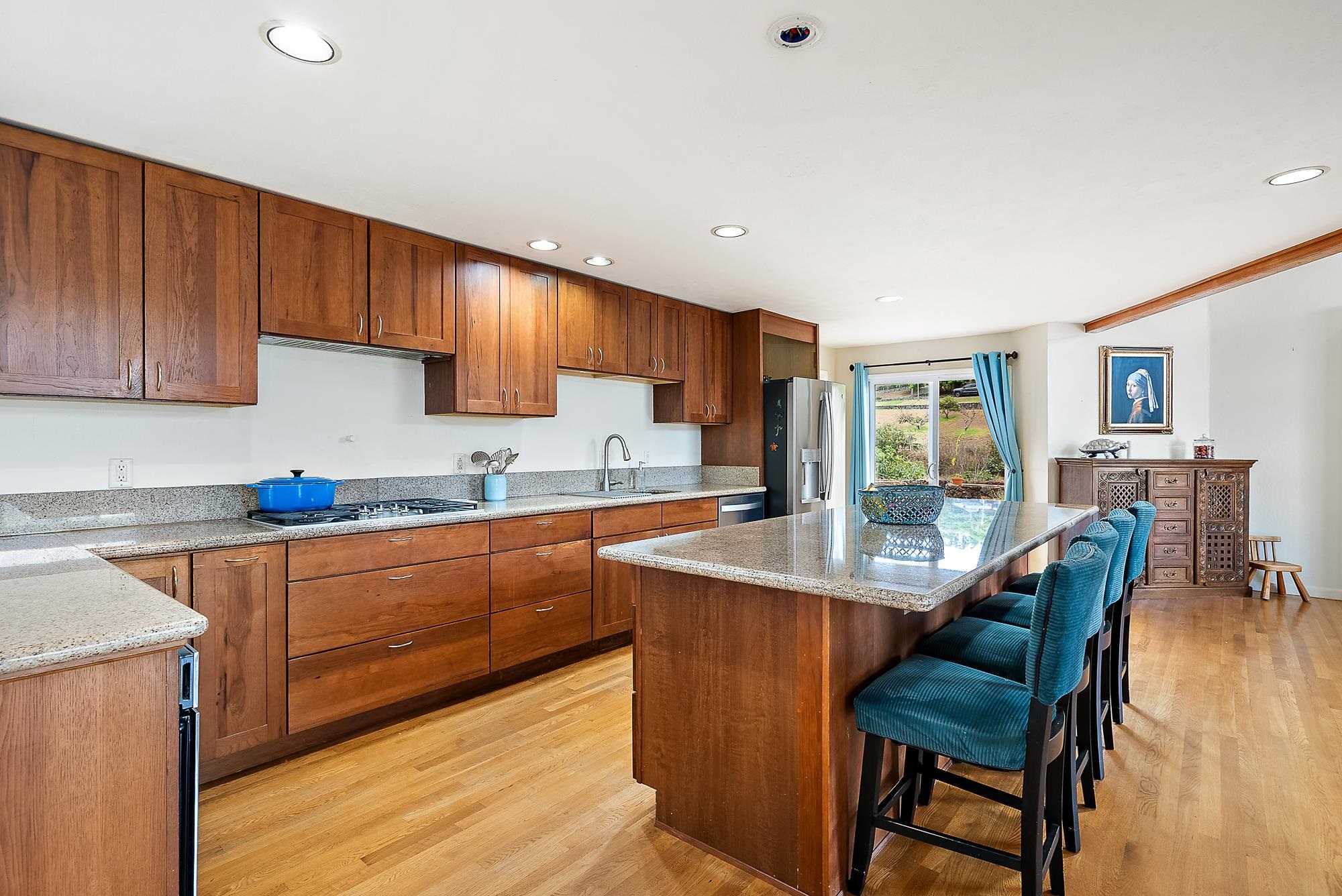 20 Pea Place Kula, HI 96790 - Photo 11 of 49 a kitchen with granite countertop wooden cabinets a stove a sink a dining table and chairs