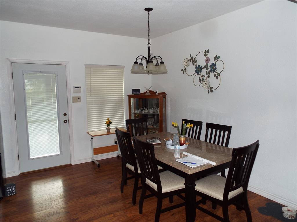 721 Midway Road Tool, TX 75143 - Photo 12 of 30 a dining room with furniture wooden floor and a chandelier