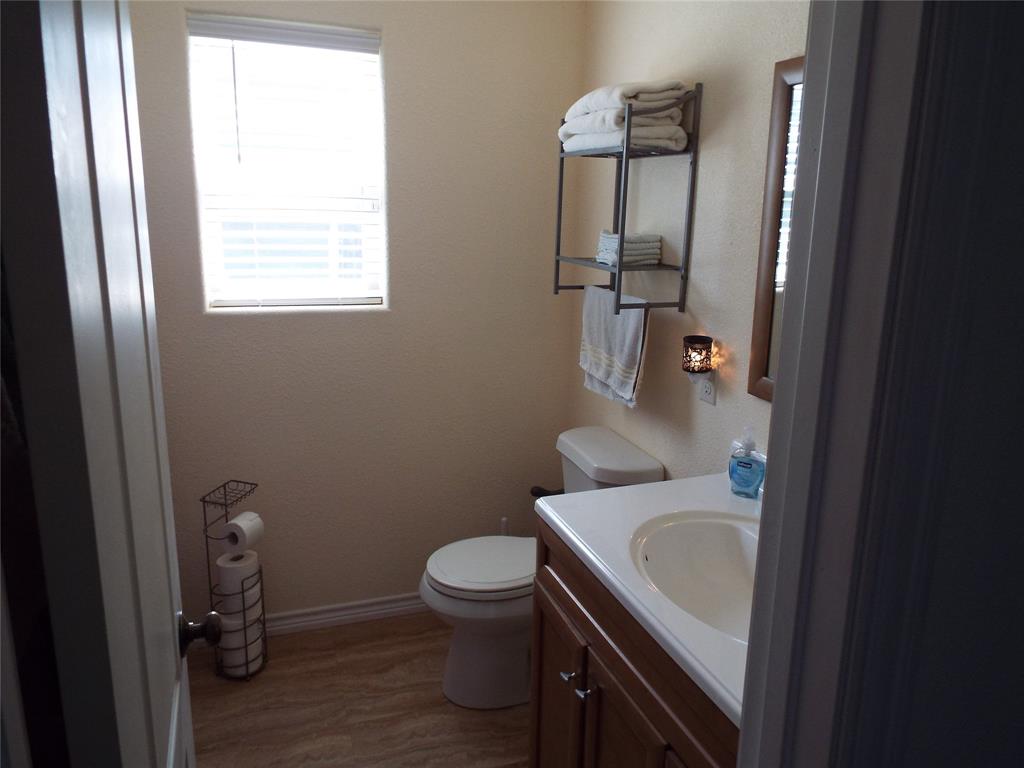 721 Midway Road Tool, TX 75143 - Photo 16 of 30 a bathroom with a sink a toilet and a mirror
