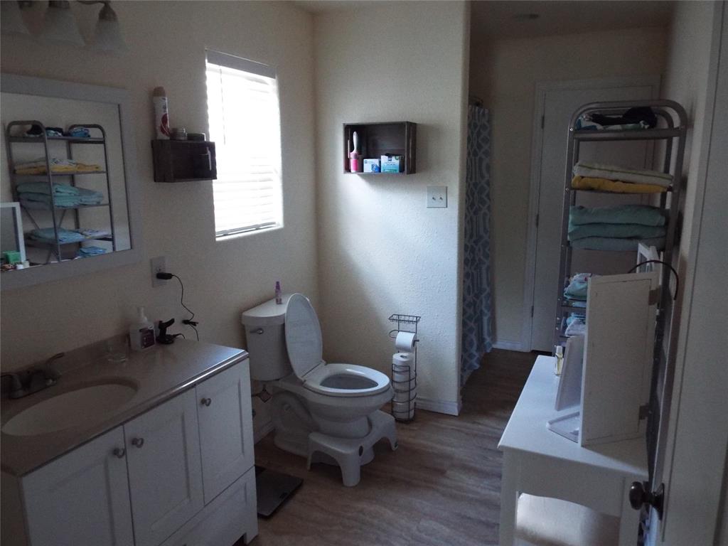721 Midway Road Tool, TX 75143 - Photo 5 of 30 a bathroom with a granite countertop toilet sink and mirror