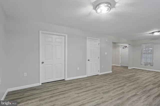 a view of empty room with wooden floor and fireplace
