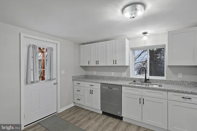 a kitchen with granite countertop a sink and a stove top oven