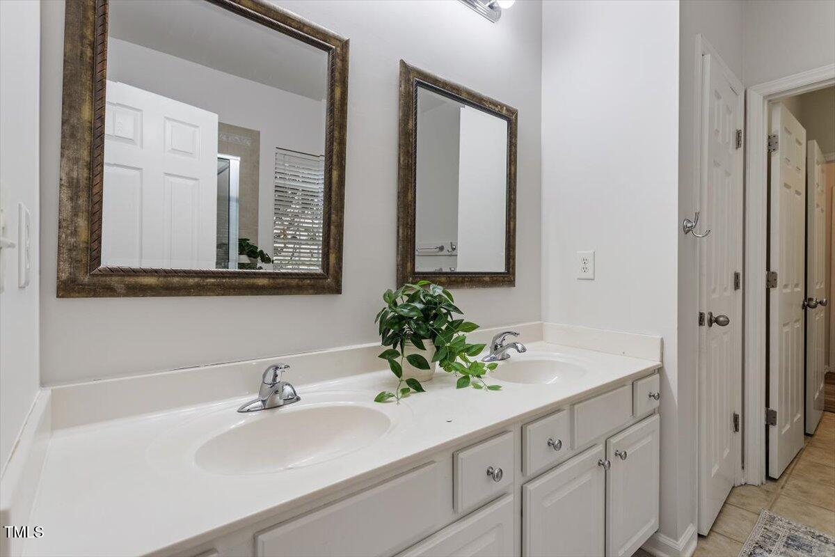 8412 Lunar Stone Place Raleigh, NC 27613 - Photo 16 of 28 a bathroom with a sink and a mirror