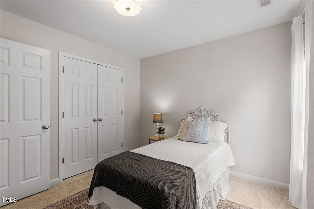 8412 Lunar Stone Place Raleigh, NC 27613 - Photo 22 of 28 a bedroom with a bed and a closet
