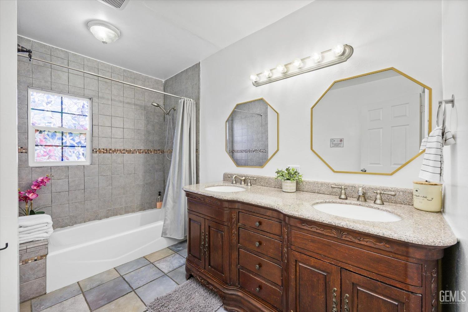 Undisclosed Address Bakersfield, CA 93312 - Photo 16 of 35 a bathroom with a double vanity sink mirror and bathtub