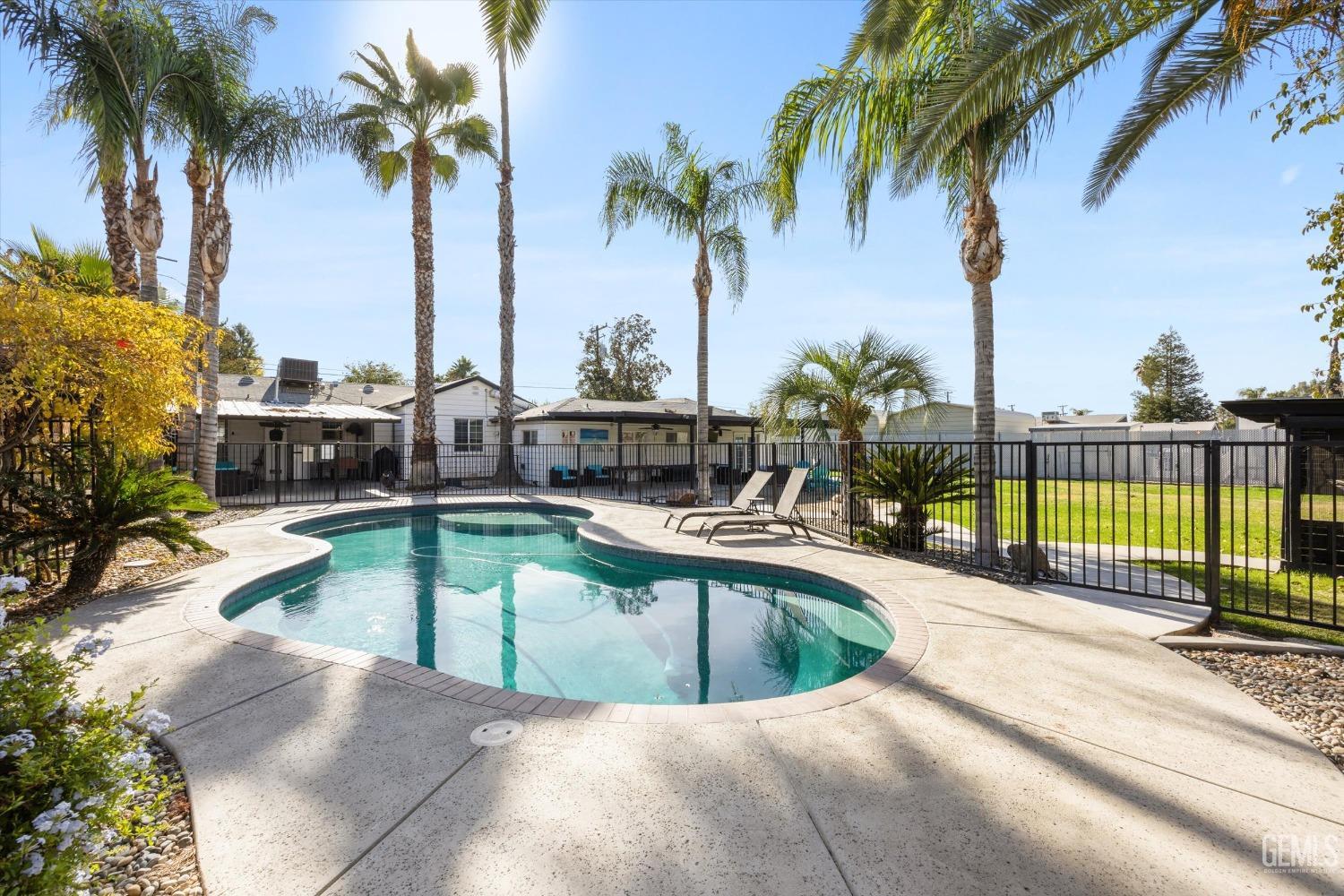 Undisclosed Address Bakersfield, CA 93312 - Photo 31 of 35 a view of a swimming pool with a chair and palm trees