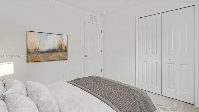 a bedroom with a bed and a painting on the wall