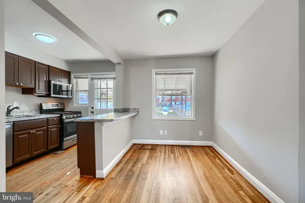 a kitchen with wooden floors and stainless steel appliances