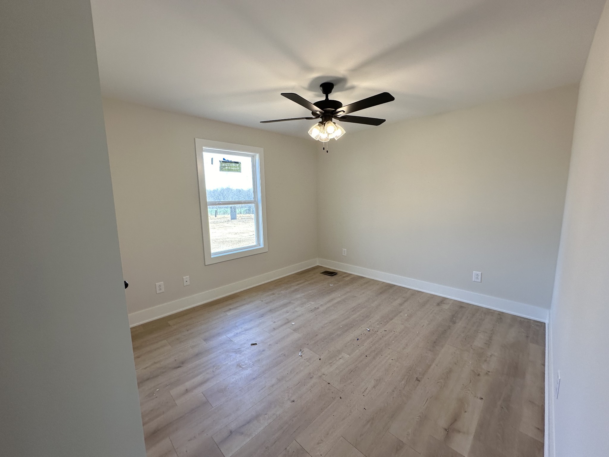 345 Jim Courtney Road Portland, TN 37148 - Photo 9 of 14 an empty room with wooden floor fan and windows