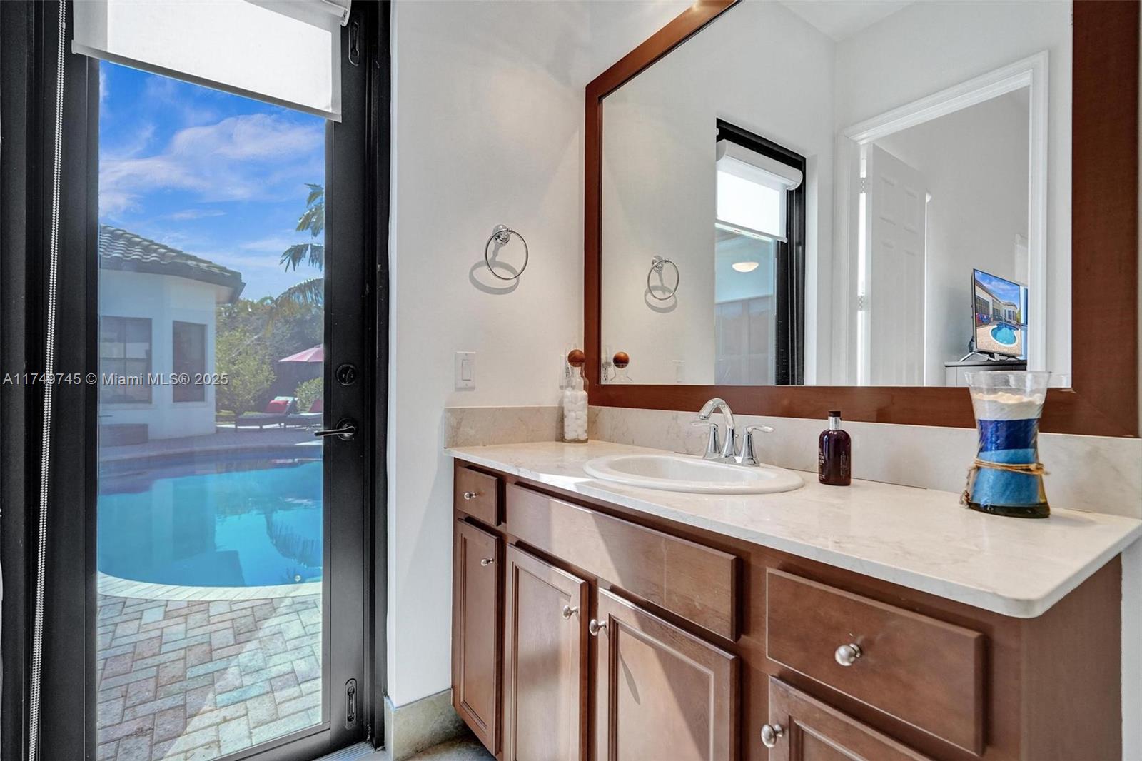 4455 Parkside Road Davie, FL 33328 - Photo 40 of 66 a bathroom with a sink and a mirror