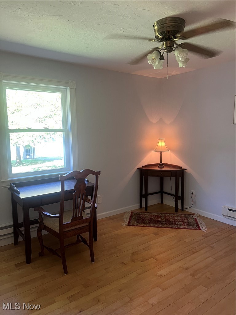 6171 Barrett Road Geneva, OH 44041 - Photo 29 of 38 Dining space with light wood finished floors, baseboard heating, a ceiling fan, and a textured ceiling