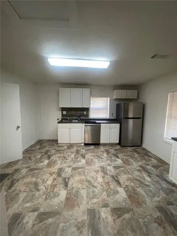 a large kitchen with a stove and a refrigerator