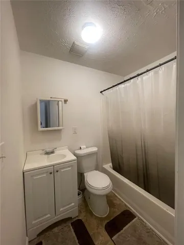 a bathroom with a toilet a sink and shower