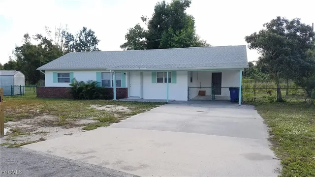 a view of a house with a yard and large tree