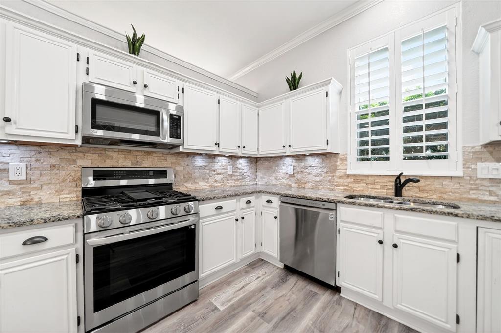 5618 Allen Lane Rowlett, TX 75088 - Photo 12 of 35 a kitchen with granite countertop cabinets stainless steel appliances and a window