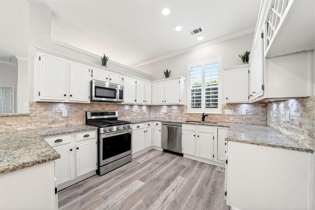 5618 Allen Lane Rowlett, TX 75088 - Photo 13 of 35 a kitchen with granite countertop white cabinets and white appliances
