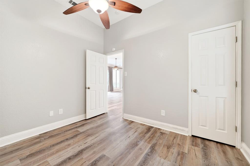 5618 Allen Lane Rowlett, TX 75088 - Photo 27 of 35 an empty room with wooden floor cabinet and ceiling fan