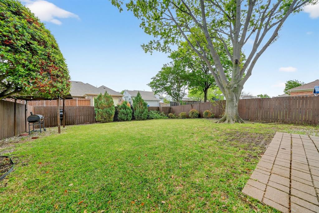 5618 Allen Lane Rowlett, TX 75088 - Photo 30 of 35 a view of a backyard with table and chairs and wooden fence