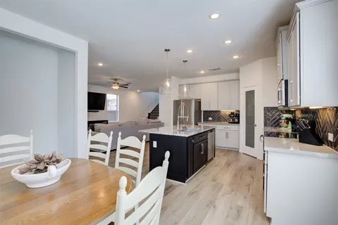 a kitchen with kitchen island granite countertop lots of counter top space and living room