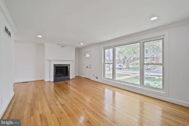 a view of empty room with wooden floor and fireplace