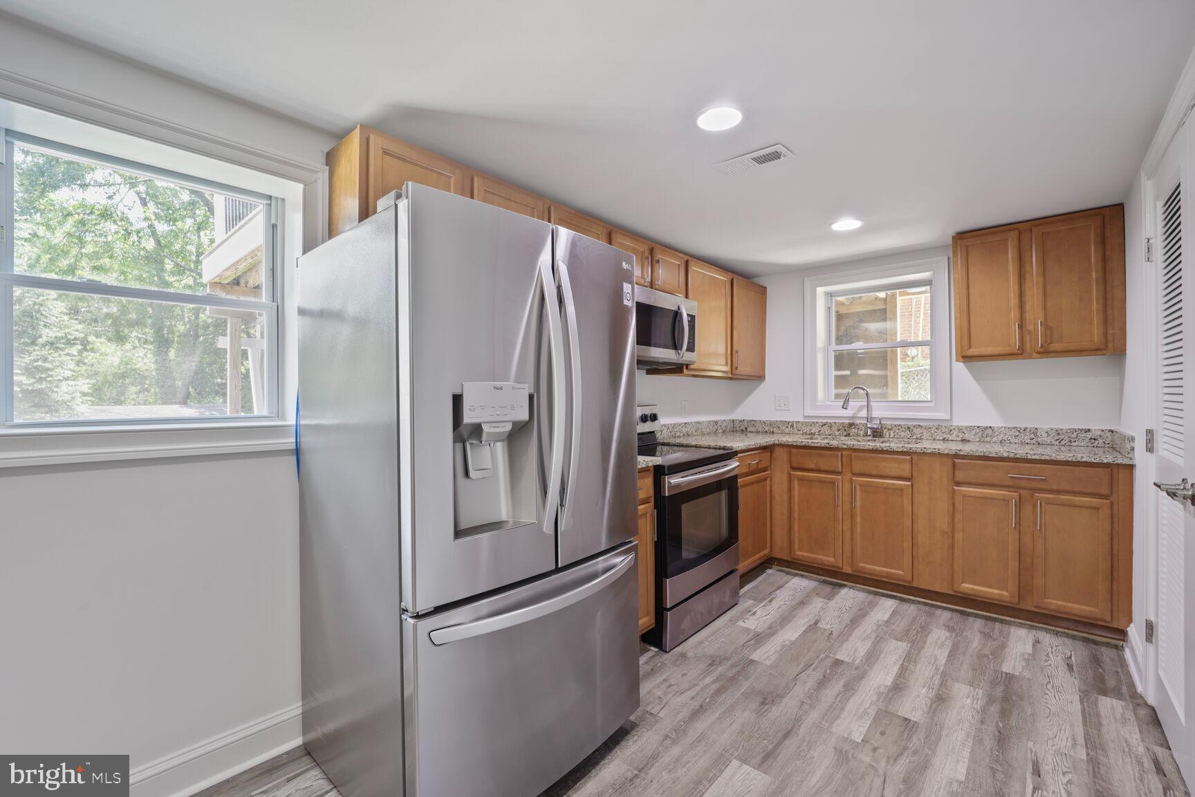 10213 Duvawn Place Silver Spring, MD 20902 - Photo 16 of 37 a kitchen with granite countertop stainless steel appliances a refrigerator sink and microwave