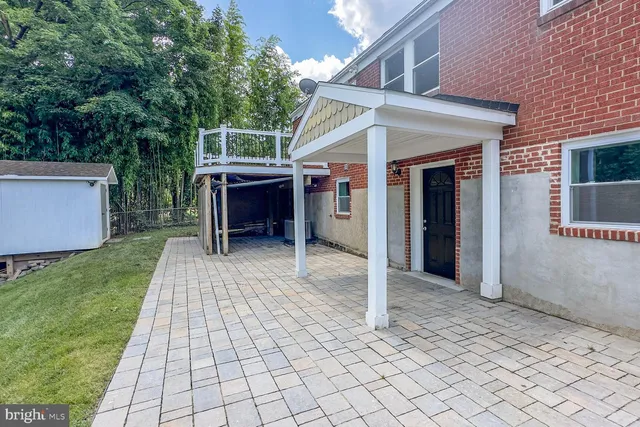 a view of a house with a backyard and trees
