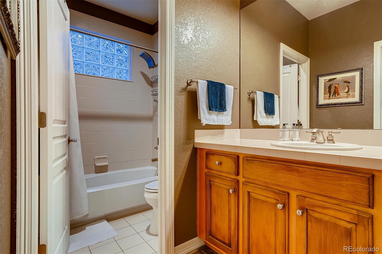 529 Uinta Way Denver, CO 80230 - Photo 21 of 40 a bathroom with a granite countertop sink a mirror a bathtub and shower