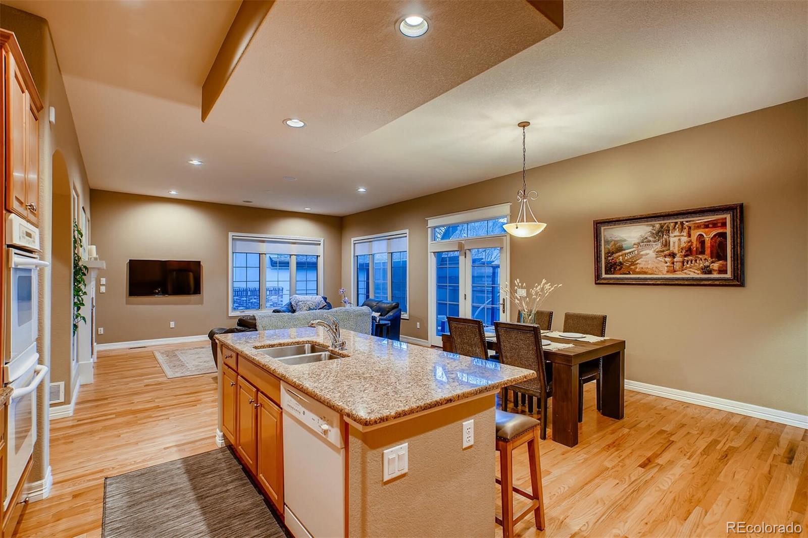 529 Uinta Way Denver, CO 80230 - Photo 7 of 40 a view of a kitchen with kitchen island a sink a table and chairs