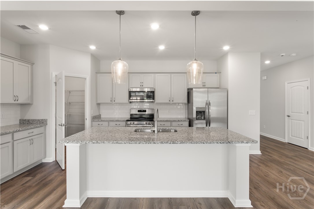 29 Blues Drive Pooler, GA 31322 - Photo 28 of 40 Gorgeous kitchen with upgrades galore, to include granite counters & tiled backsplash, upgraded level and height of cabinets, pendant island lights and more!