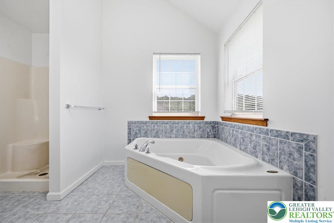 66 Labar Road Bangor, PA 18013 - Photo 25 of 56 Relaxation awaits in this well-lit bathroom featuring a large corner soaking tub and tiled walls.