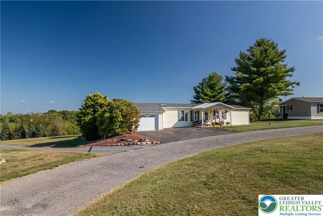 a front view of a house with a yard and trees
